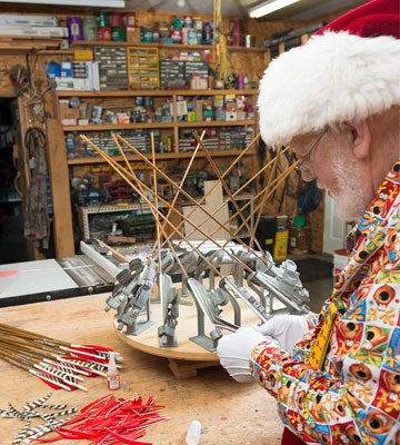 Santa Clause fletching up some arrows on a fletching jig table