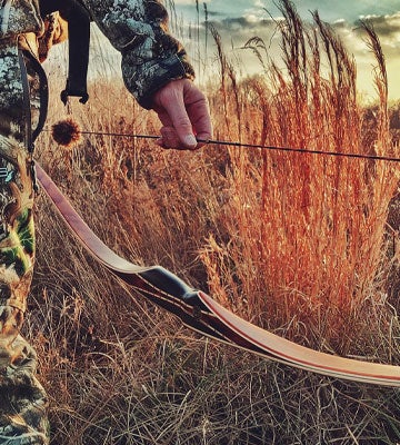 Bowhunter with a Tomahawk longbow in the field